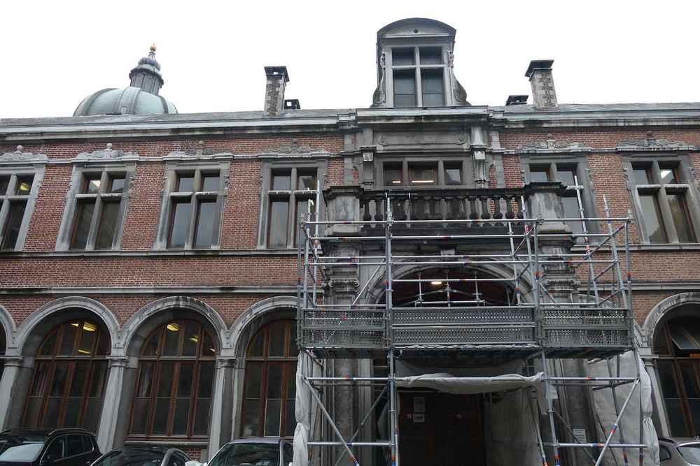Extérieur du Palais de Justice de Première Instance de Namur. Bâtiment d’extérieur, échafaudage sur la porte principale. Un bout de coupole qui dépasse.
